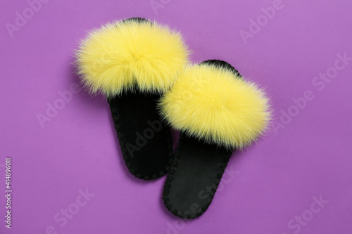 Pair of soft slippers on violet background, flat lay