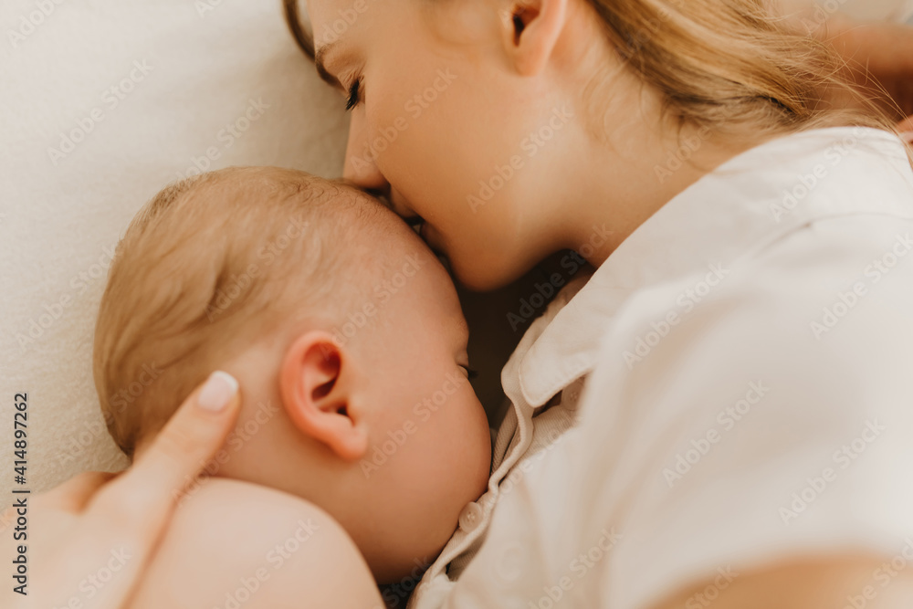Beautiful young mom and her cute little baby sleeping in bed Beautiful young mom and her cute little baby sleeping in bed