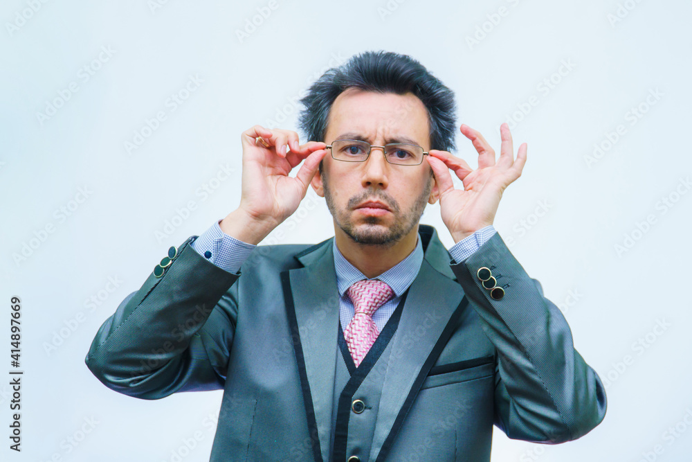 A man with disheveled hair in a business suit adjusts his glasses A man with disheveled hair in a business suit adjusts his glasses