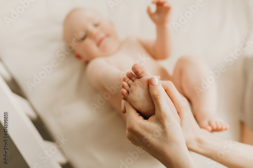 Mother and her cute baby on the bed, baby massage