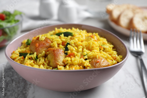 Delicious rice pilaf with meat in bowl, closeup
