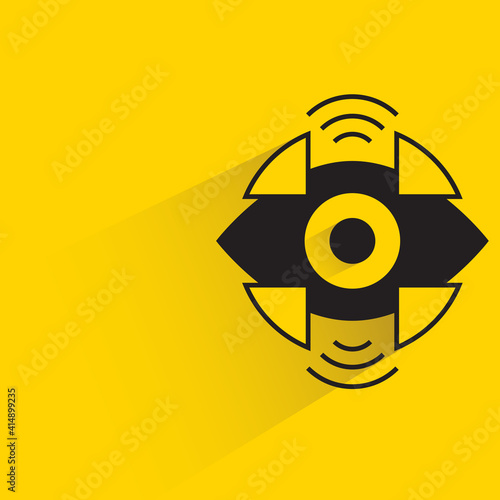 robotic eye with shadow on yellow background