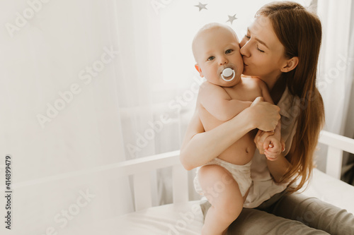 Happy family, child and parenting concept, young mom hugs her little child