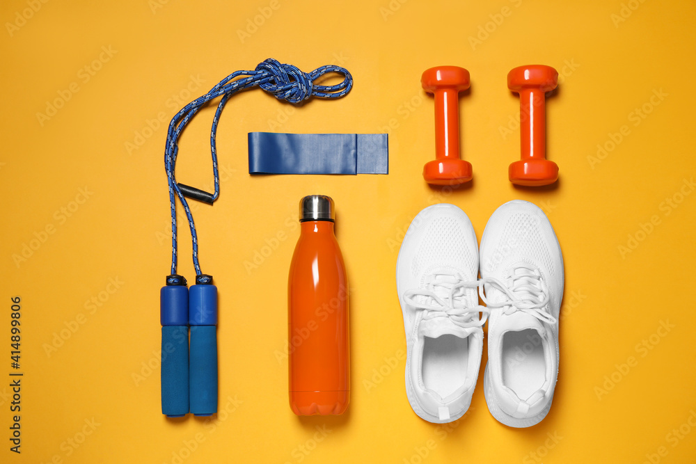 Flat lay composition with sports accessories on orange background