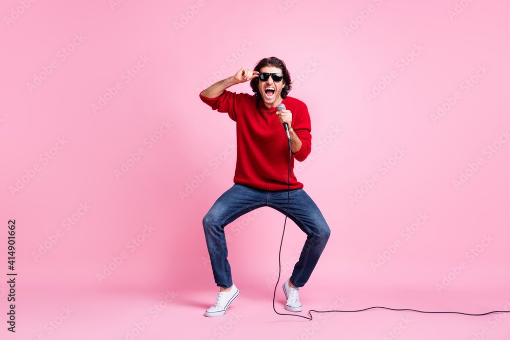 Full body photo of young excited man happy crazy positive smile have fun sing song concert isolated over pink color background