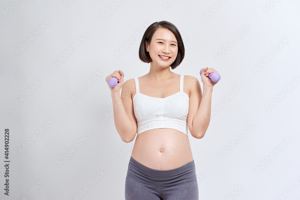 Pregnant woman training with dumbbells Pregnant woman training with dumbbells
