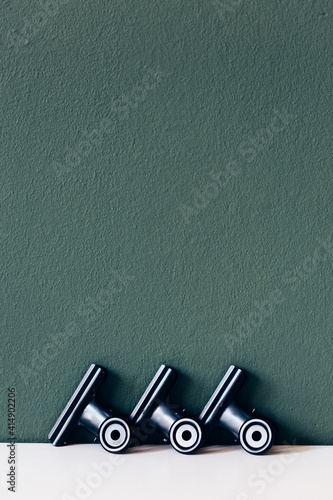 schwarze Metallklammer vor grüner Wand | Bürozubehör, Papierklammer, Bulldog Clip, Büroklammer