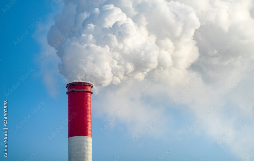 Chimney with smoke against the blue sky.. Chimney with smoke against the blue sky..