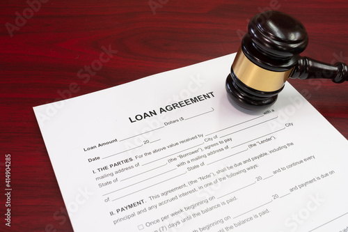 Law, loan in business concept. Gavel with business loan agreement as legal document concept. Gavel with loan agreement contract preparation for filling.