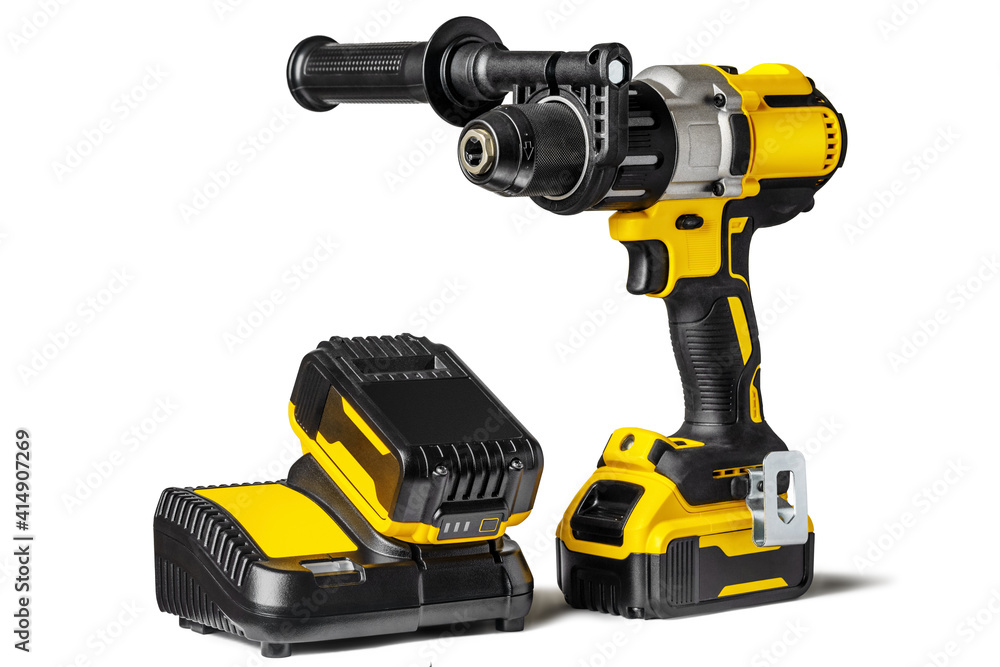 Yellow-black cordless Combi Drill Driver Hammer Drill and extra battery with charger isolated on white background. Yellow-black cordless Combi Drill Driver Hammer Drill and extra battery with charger isolated on white background.