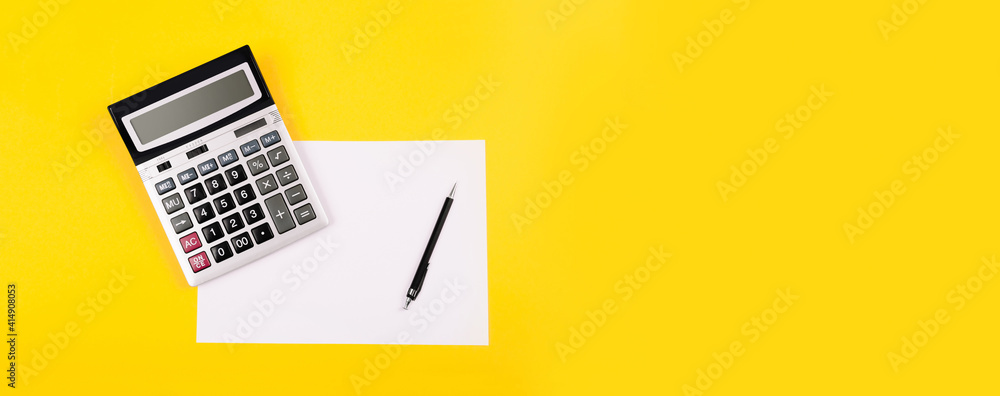 Banner with big financial silver calculator, black pen and white paper on  yellow background with copy space, empty text place. Distance online  education. Calculation of bank loan for business. Mockup Stock Photo