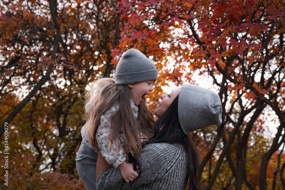 Mother and daughter walking in the park and enjoying autumn nature. Mother and daughter walking in the park and enjoying autumn nature.