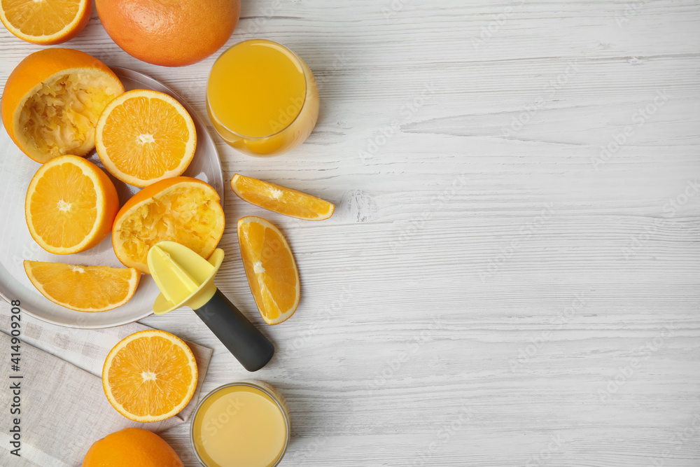 Fresh oranges, reamer and juice on white wooden table, flat lay. Space for text Fresh oranges, reamer and juice on white wooden table, flat lay. Space for text