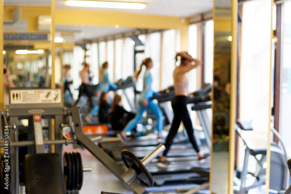 Defocused background of treadmills with people in the gym.