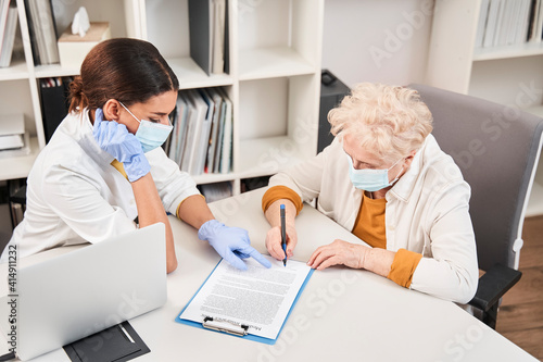 Woman putting signature on health insurance agreement