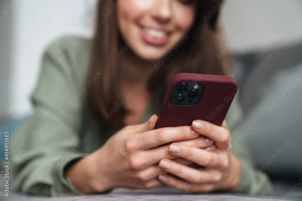 Close up of a smiling attractive woman holding mobile phone Close up of a smiling attractive woman holding mobile phone