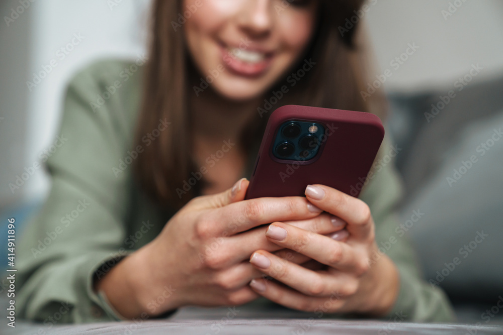 Close up of a smiling attractive woman holding mobile phone Close up of a smiling attractive woman holding mobile phone