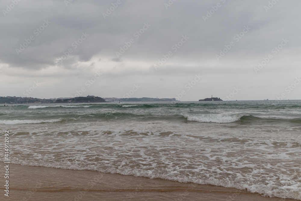 Cloudy coast landscape with an island and brave waves, Cantabria, Spain