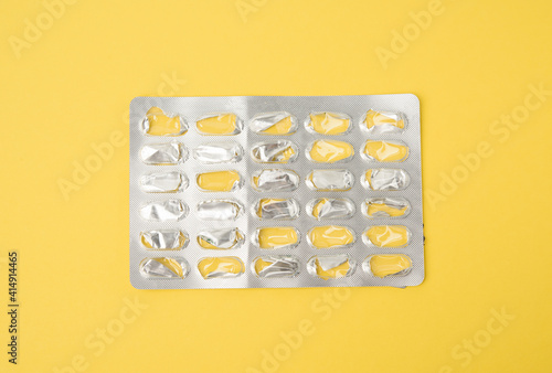 blank blister pack of capsule pills on a yellow background photo