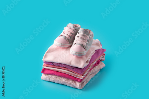 Baby rompers and baby shoes on blue background photo