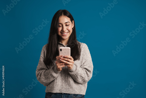 Happy beautiful asian girl smiling and using smartphone