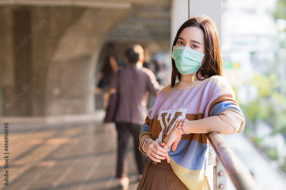 Asian woman in colorful sweater wears medical face mask in health care,pollution PM2.5 and new normal concept..