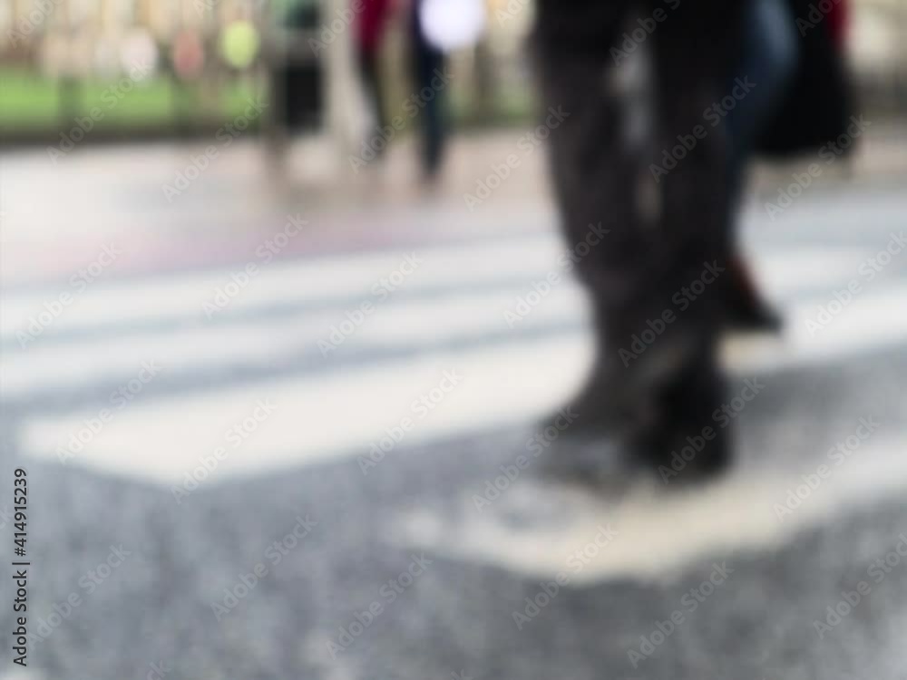 Slow motion blurred shot of people, legs and feet, walking across a pedestrian zebra crossing Slow motion blurred shot of people, legs and feet, walking across a pedestrian zebra crossing