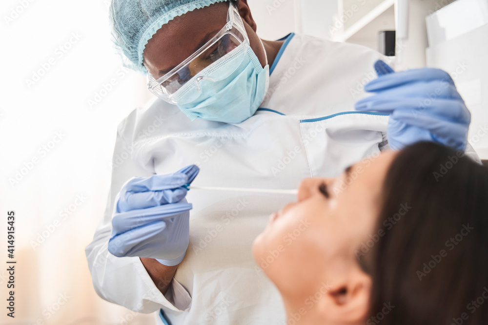 Medical lab technician collecting mucus from patient nose Medical lab technician collecting mucus from patient nose