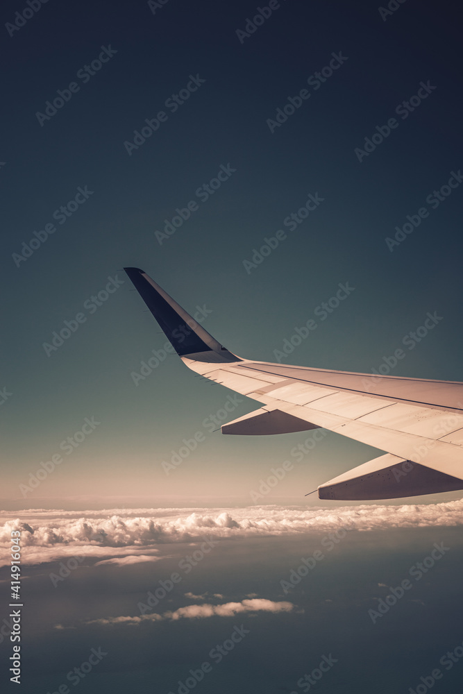 Fototapeta premium Top view from inside window airplane of a blue sky and wing