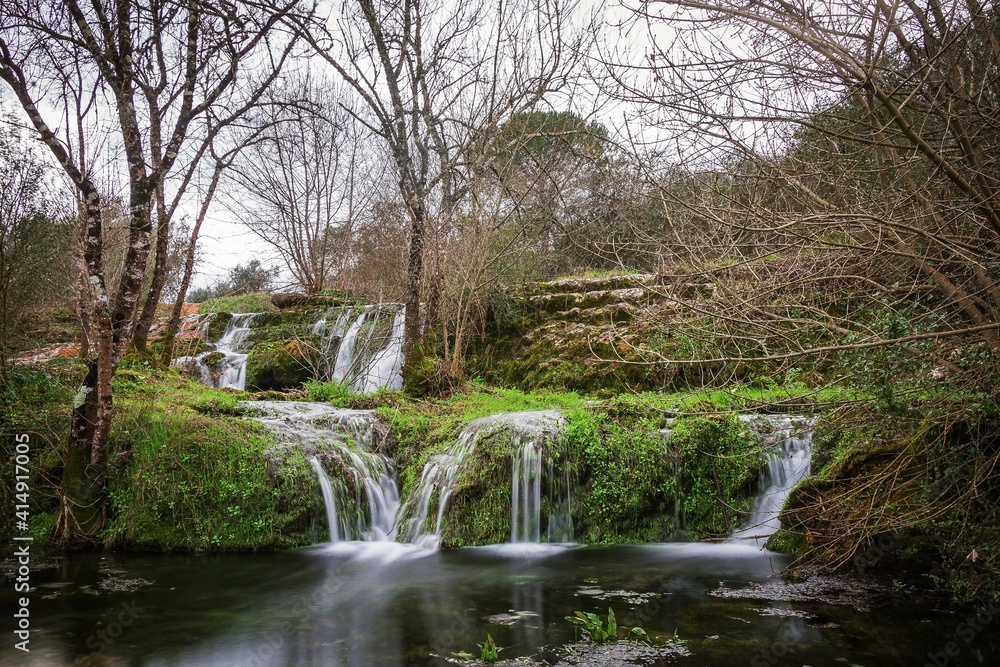 Waterfall in the forest of Beselga de Cima, Portugal. River waterfall with moss covered stones and rocks Waterfall in the forest of Beselga de Cima, Portugal. River waterfall with moss covered stones and rocks