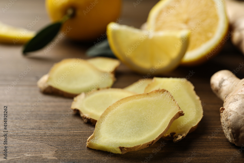 Cut ginger and lemon on wooden table, closeup