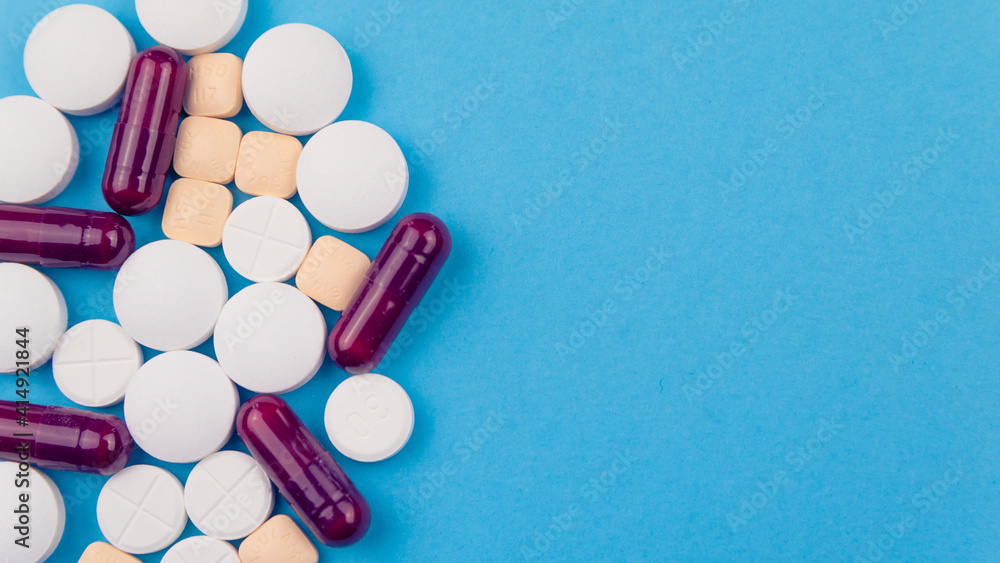 Overhead shot of several pills and a thermometer. Concept of drugs for the treatment of diseases, especially against Covid-19 Overhead shot of several pills and a thermometer. Concept of drugs for the treatment of diseases, especially against Covid-19