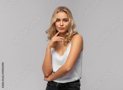 Beautiful blonde female model isolated on gray background