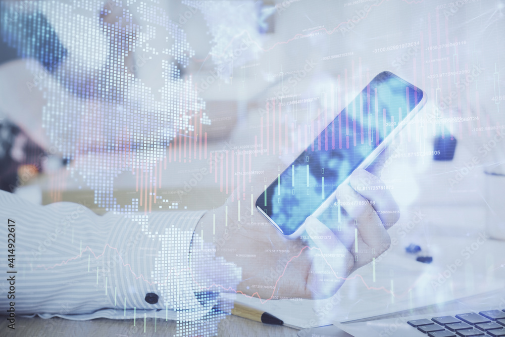 Double exposure of man's hands holding and using a digital device and forex graph drawing. Financial market concept. Double exposure of man's hands holding and using a digital device and forex graph drawing. Financial market concept.