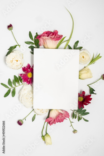 Fototapeta Naklejka Na Ścianę i Meble -  Floral arrangement and blank card on a white background. Mothers day and international womens day concept. Floral frame and Copy space. 