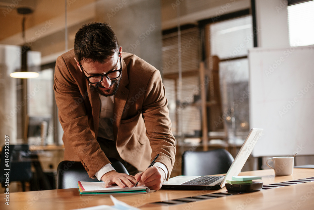 Young businessman working on laptop in his office. Handsome man having video call. Young businessman working on laptop in his office. Handsome man having video call.