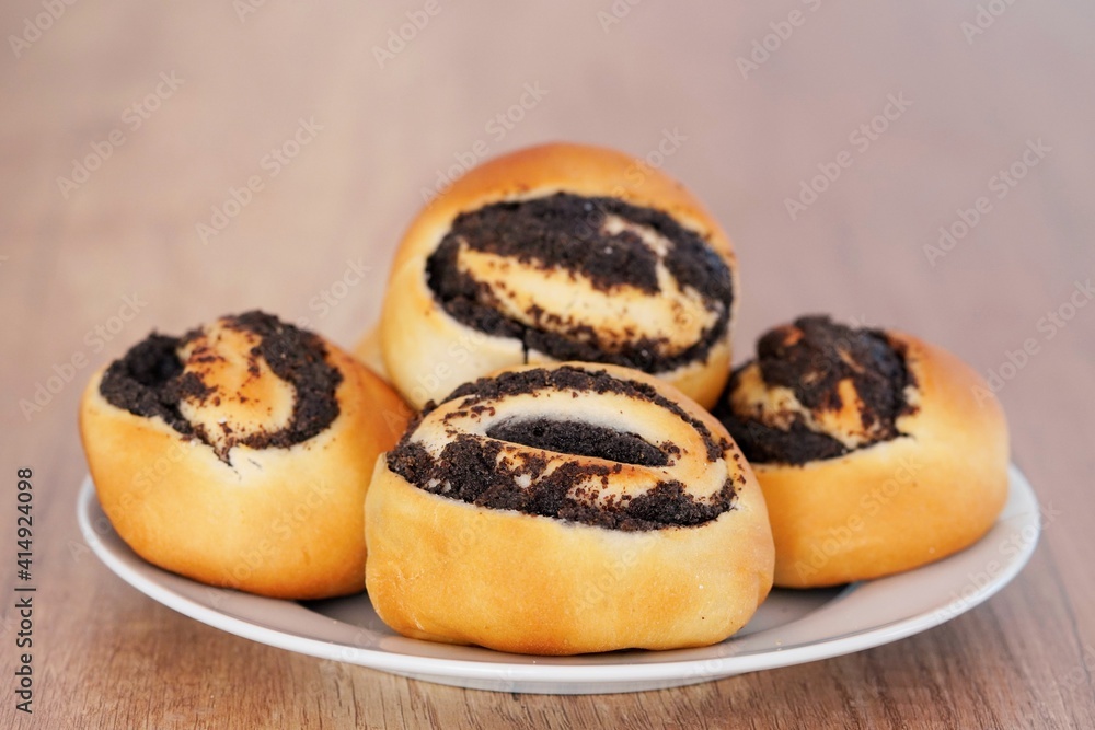 Nahaufnahme vom Mohngebäck aus Hefeteig. Gebäck mit Mohn. Mohnbrötchen. Nahaufnahme vom Mohngebäck aus Hefeteig. Gebäck mit Mohn. Mohnbrötchen.