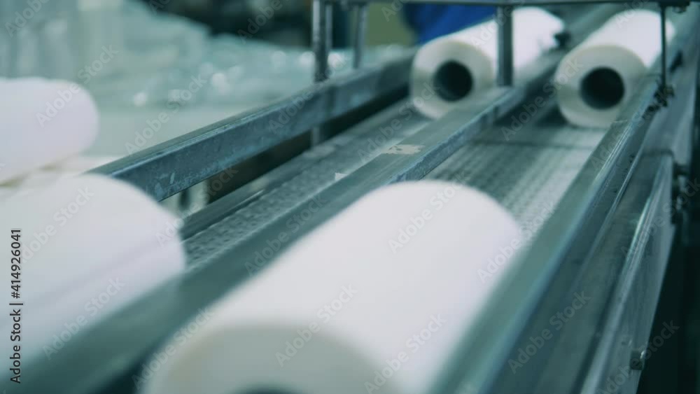 Small paper rolls moving along the conveyor belt Small paper rolls moving along the conveyor belt