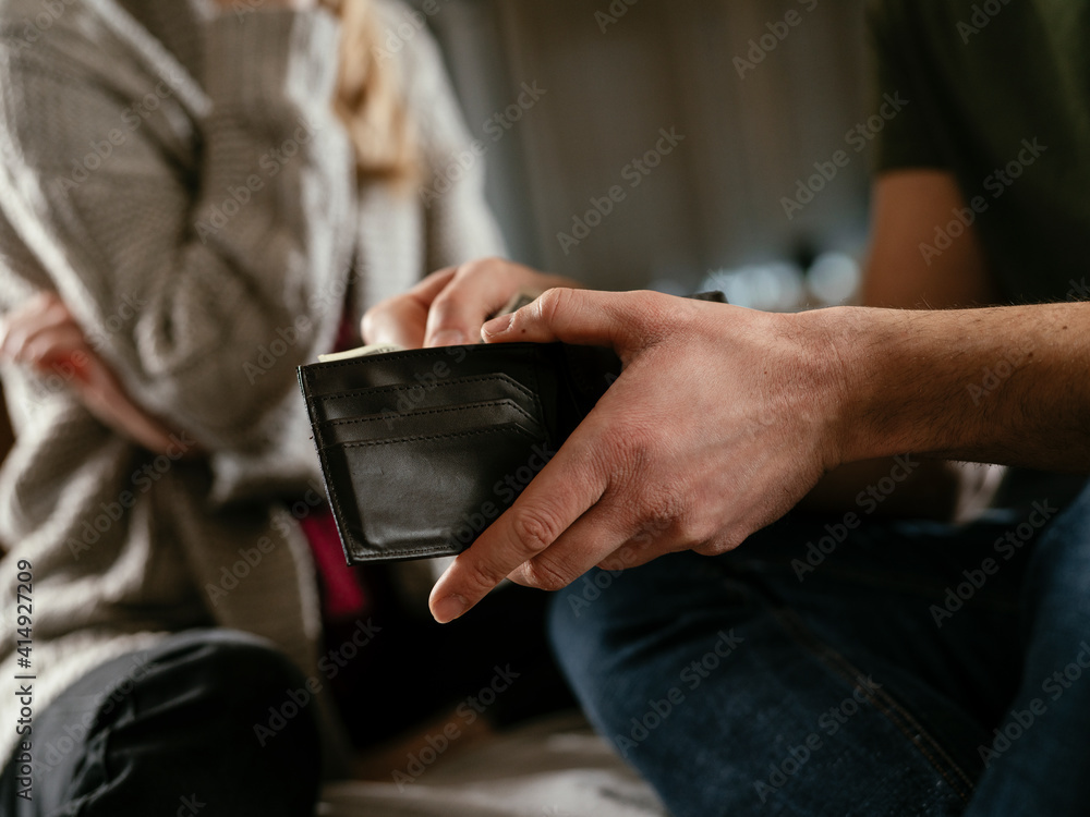 Young man checking empty wallet, no money. Unemployed sad man sitting at home showing empty wallet. Young man checking empty wallet, no money. Unemployed sad man sitting at home showing empty wallet.