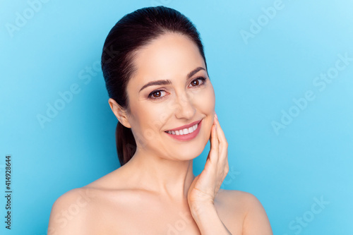 Photo of young woman happy positive smile hand touch cheek perfect silky skin cream collagen isolated over blue color background