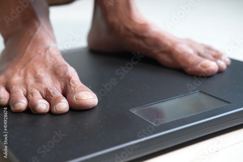 senior women feet on weight scale close up.