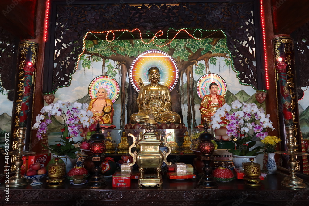 Hoi An, Vietnam, February 18, 2021: Altar with images of Buddha in the main hall of the Phap Bao Temple. Hoi An, Vietnam