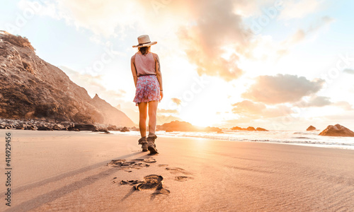 Woman walking on the beach enjoying sunset - Inspirational concept about success  travel and health.
