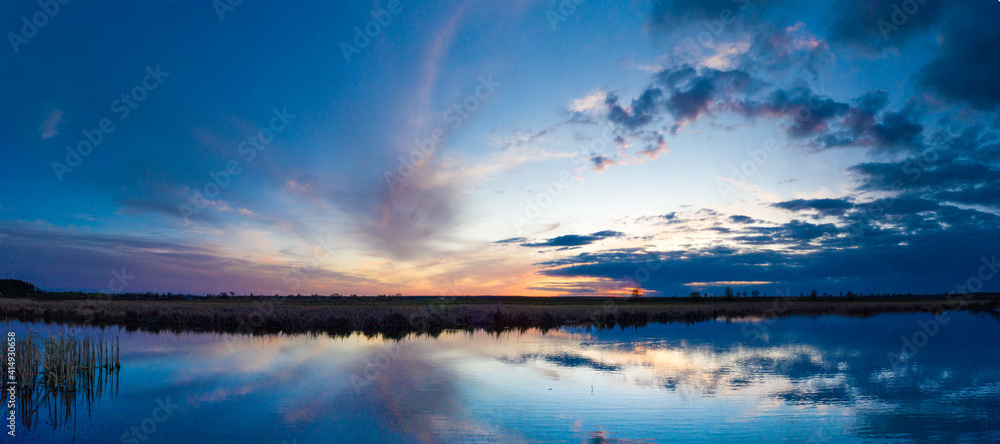 Beautiful sunrise and dramatic clouds on the sky. Flood waters of river. Panorama landscape Beautiful sunrise and dramatic clouds on the sky. Flood waters of river. Panorama landscape