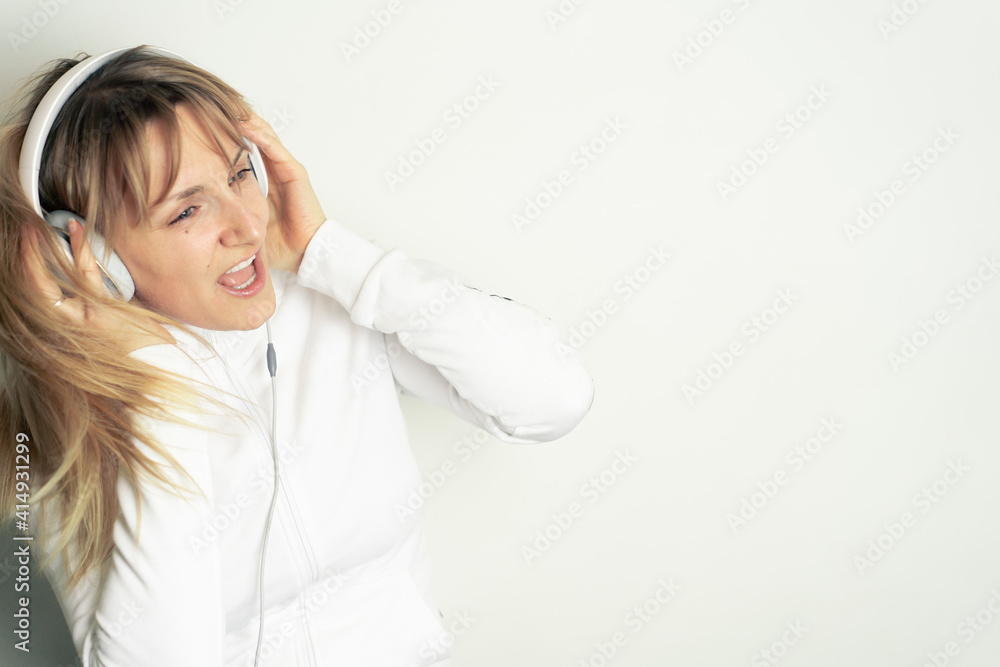 Portrait of smiling pretty woman enjoying music with white headphones on white background Portrait of smiling pretty woman enjoying music with white headphones on white background