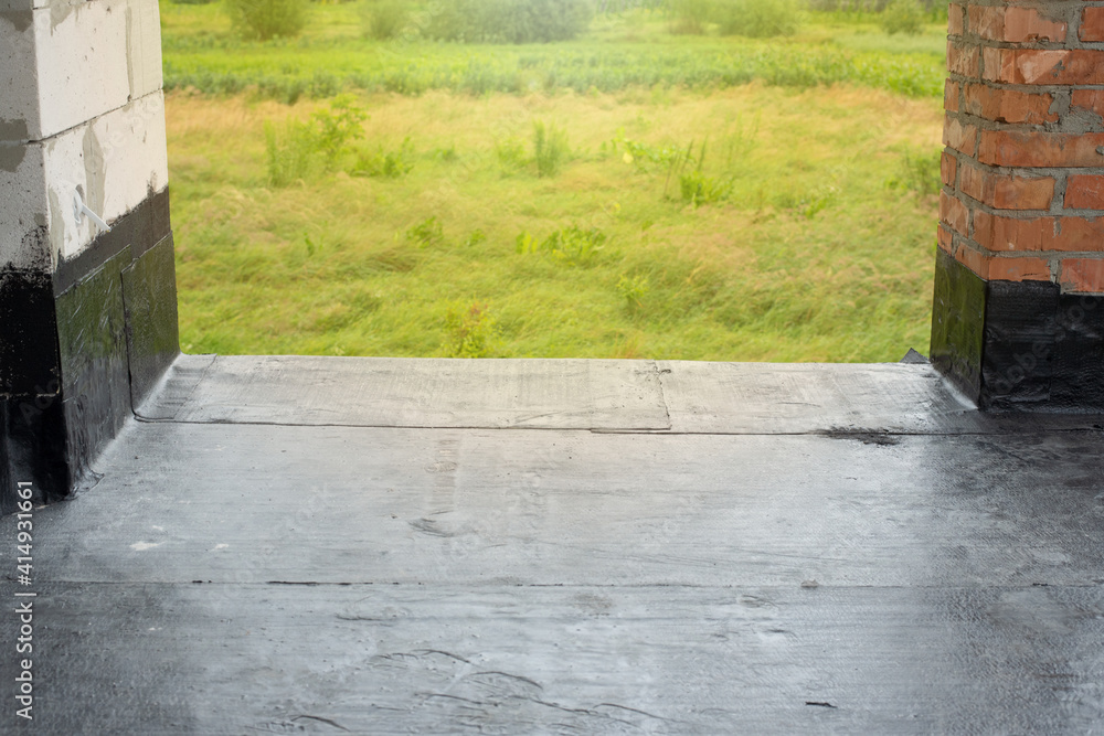 Waterproofing flat roof terrace with bitumen roofing material. Stock