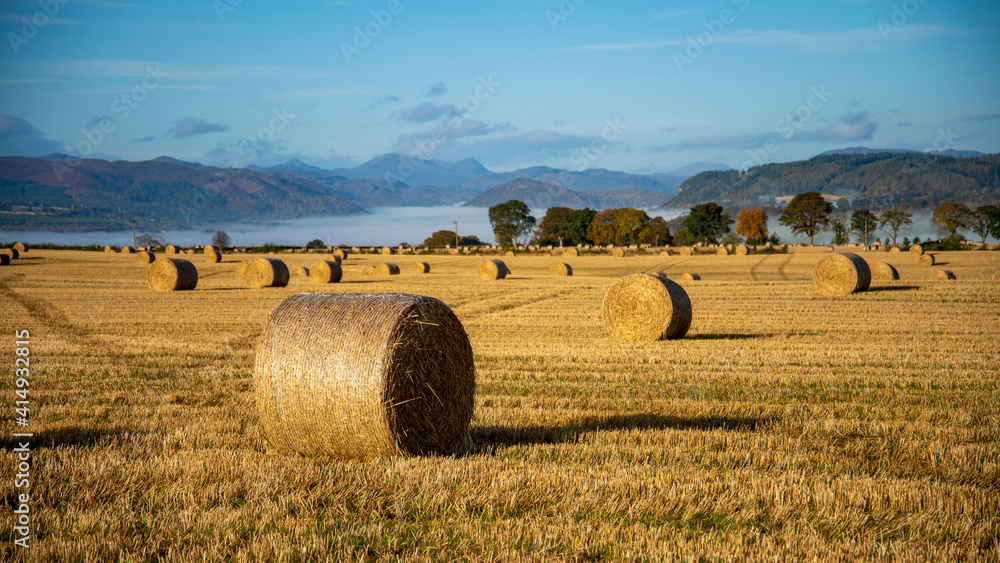 hay bales in the field with a temperature inversion in the mountains