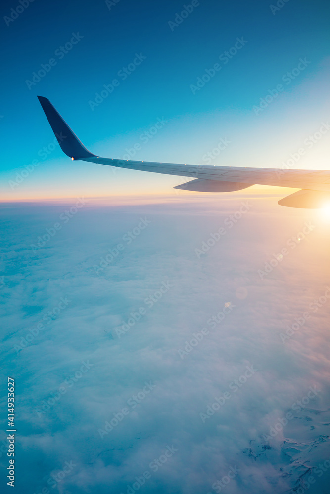 Top view from inside window airplane of a sunset sky and wing Top view from inside window airplane of a sunset sky and wing