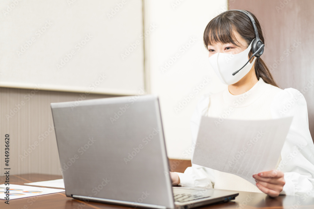 Woman wearing a headset with mask and having a web conference Woman wearing a headset with mask and having a web conference