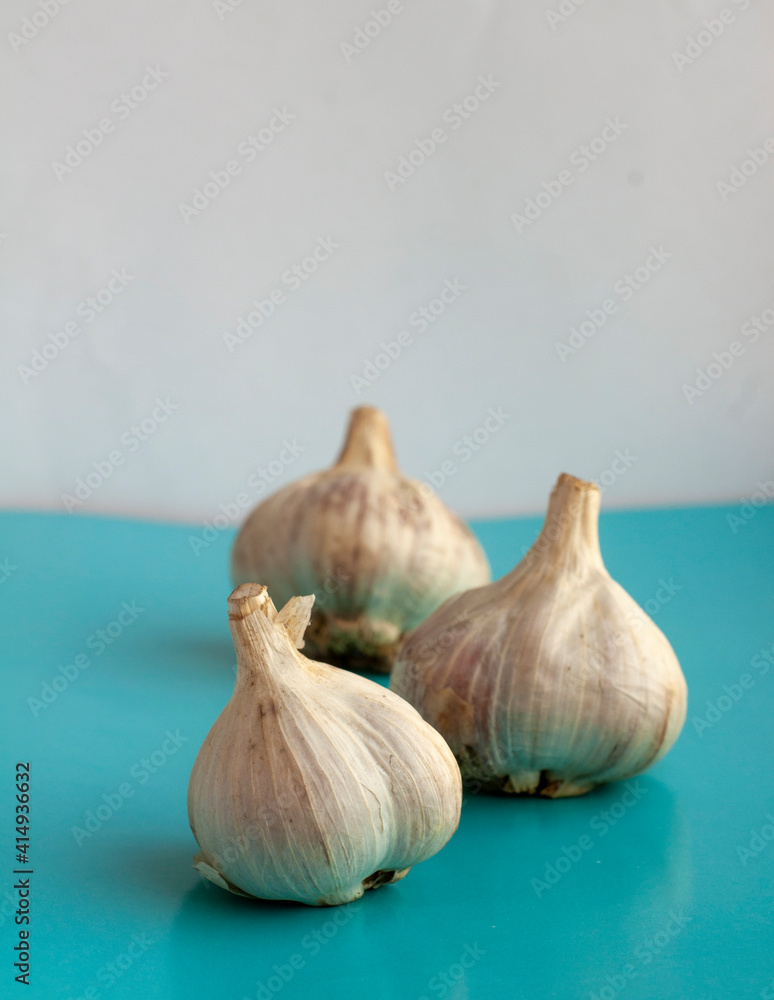 Obraz premium garlic on a turquoise background. garlic harvest of 2020. folk remedy for colds and viruses
